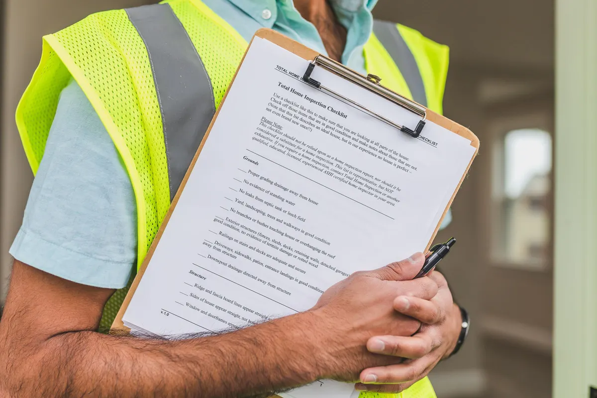 Close-up of an inspector holding a checklist on a clipboard